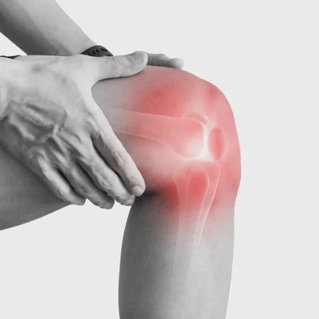 A man holding his knee, pain indicated with red highlighting